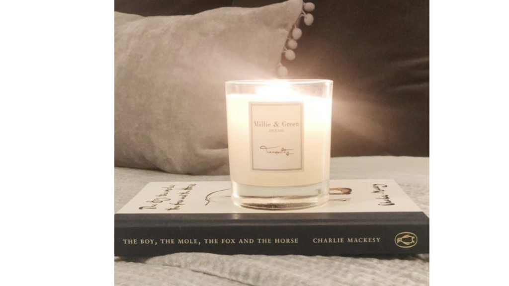 lit candle on a bed