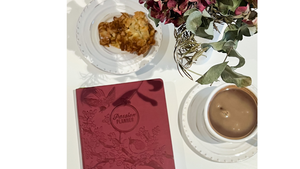 planner with a cup of tea, biscuits on a plate with flowers
