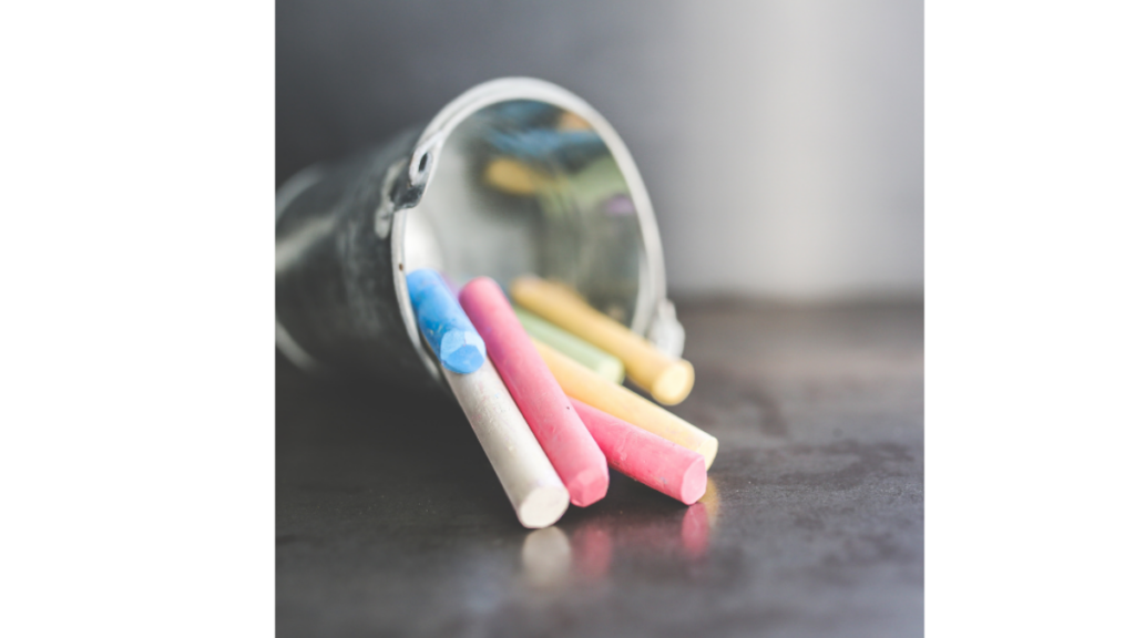 little stainless steel bucket tipped over with coloured chalk sticks