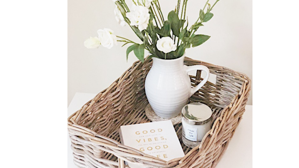 basket filled with a book, candles and vase of flowers