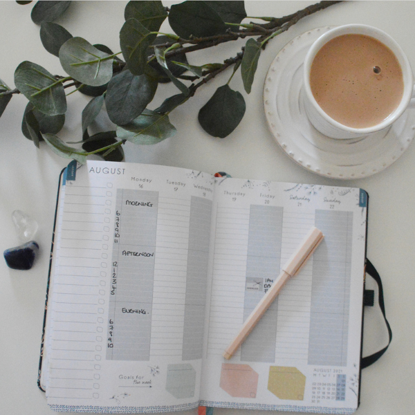 Open diary with a cup of coffee, highlighting how useful the planner is to see the week ahead