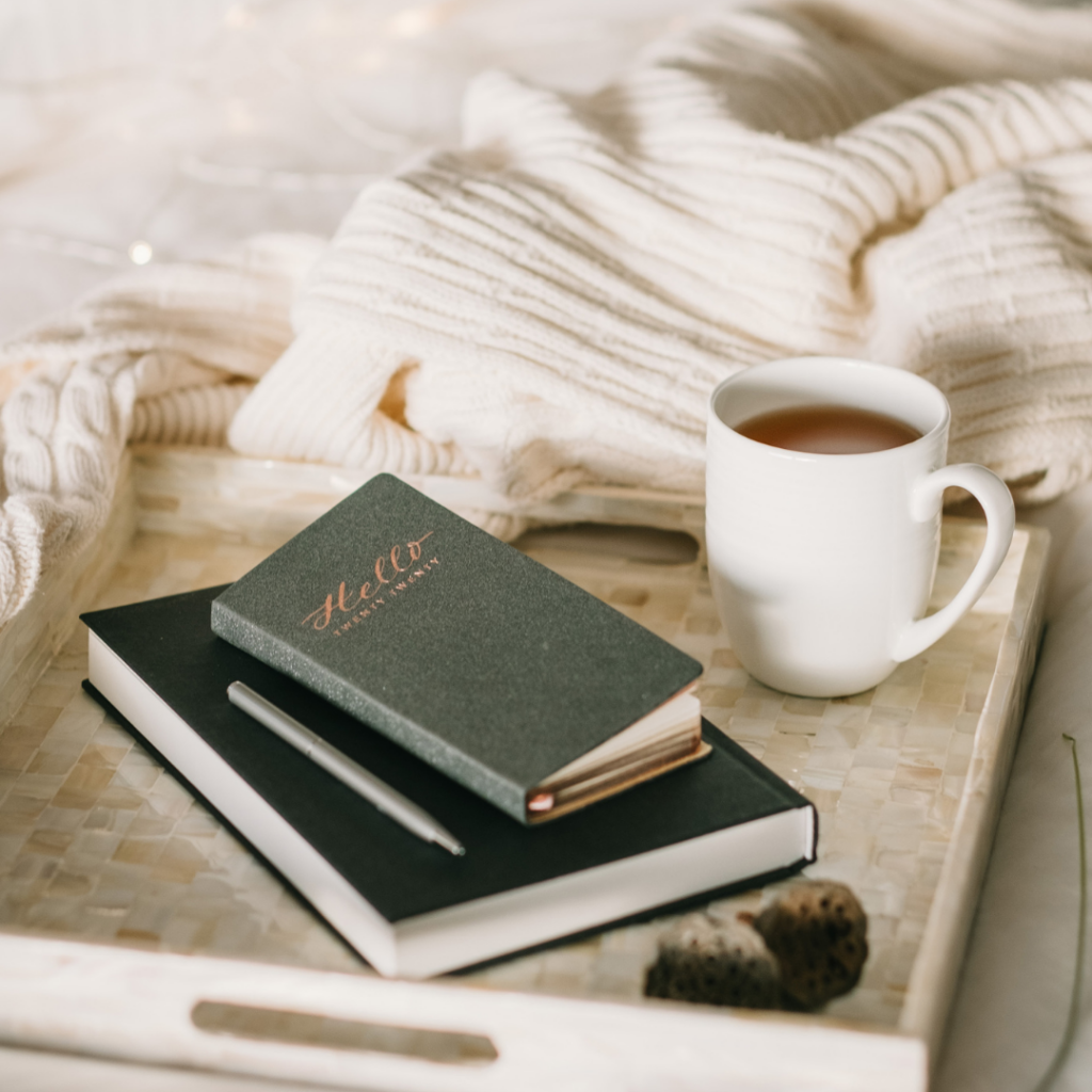journals on a tray with a mug and cosy jumper