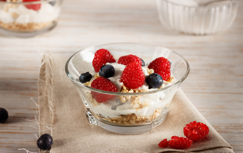 Start your morning right with a healthy, feel good breakfast. Bowl of fruit with yogurt and granola on a napkin 