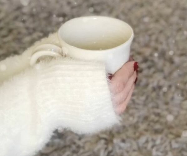 mug of hot chocolate being held ny hands in a fluffy jumper