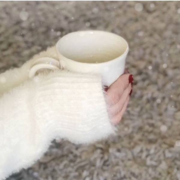 mug of hot chocolate being held ny hands in a fluffy jumper